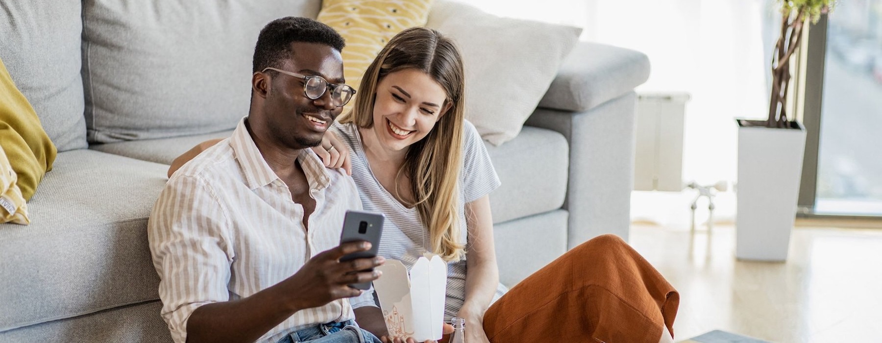 two people sitting on the ground looking at a phone